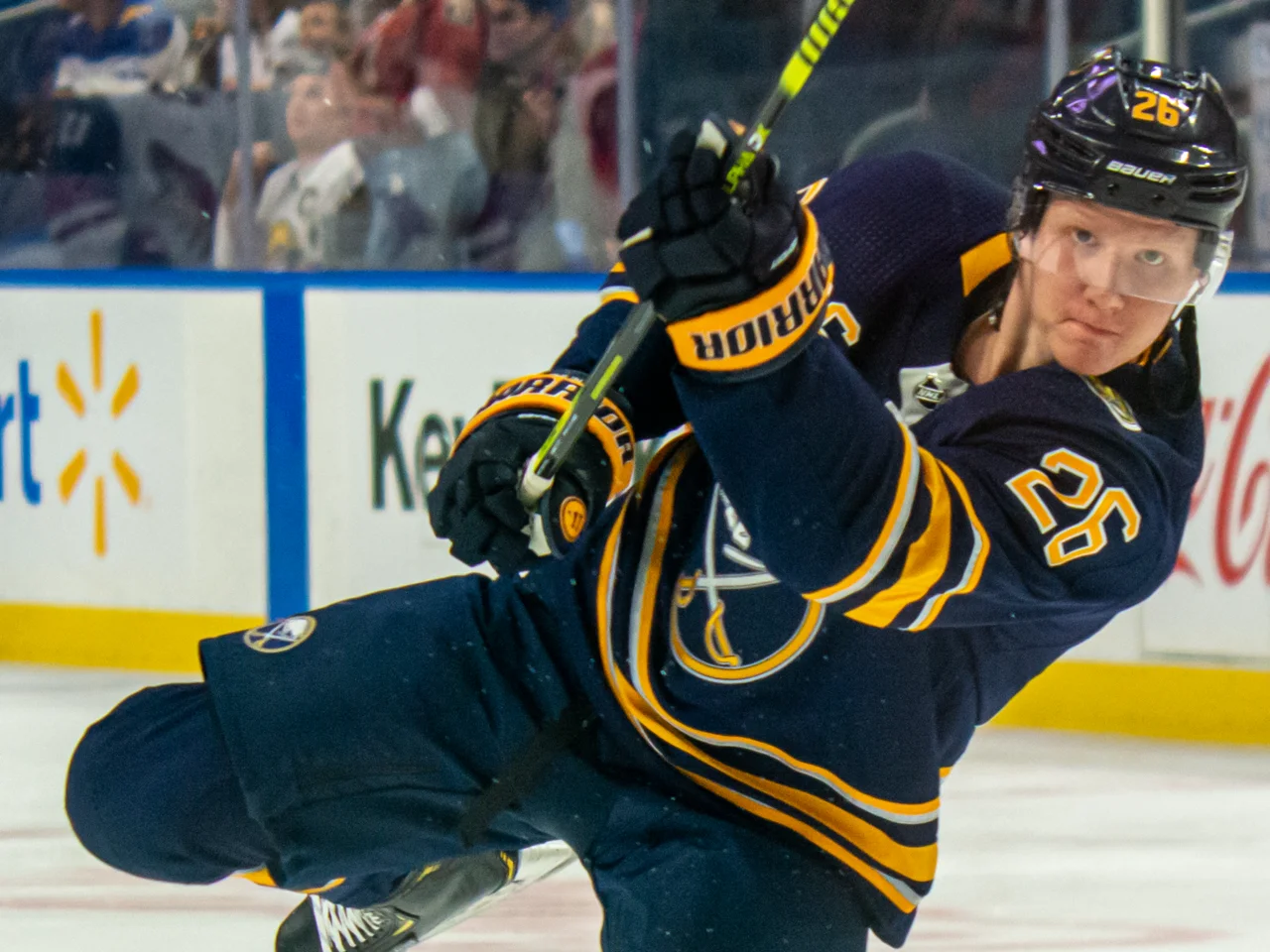 Rasmus Dahlin i Buffalo Sabres mörkblå matchtröja med nummer 26 skjuter pucken på isen
